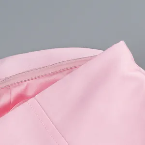 Gros plan sur une robe rose montrant les détails de la fermeture éclair et du tissu.