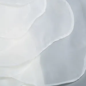 Macro view of delicate white organza layers on a high-end one-shoulder flower party dress