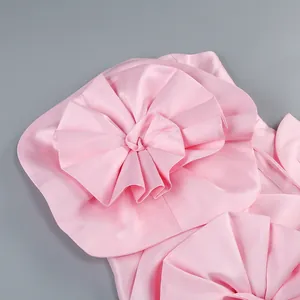Gros plan sur le détail de la fleur en tissu 3D d'une robe bustier rose effet satiné