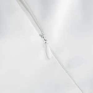Macro view of white invisible zipper detail on high-quality satin evening dress
