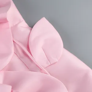 Gros plan sur le décor de pétales rose délicat et le tissu en satin de haute qualité de la robe