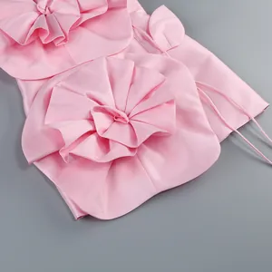 Vue détaillée des ornements floraux en tissu tridimensionnels sur une robe en satin rose