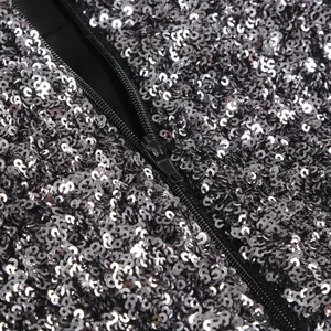 High-quality close-up detail of silver sequins and black zipper on an elegant party dress