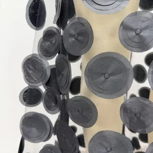 Macro view showing the intricate black 3D floral applique on delicate mesh fabric.
