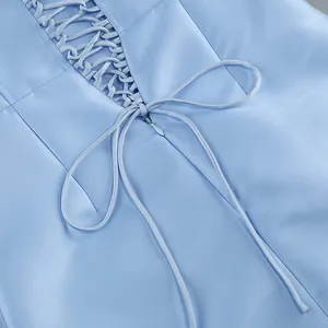 Détail d'une robe bleu clair montrant un élégant design de laçage au dos avec nœud