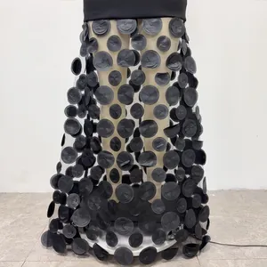 Detailed view of 3D circular fabric petals on black mesh strapless maxi dress skirt