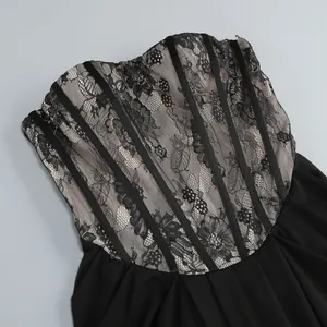 Dettaglio di un elegante abito a fascia in pizzo nero con strisce di velluto nero