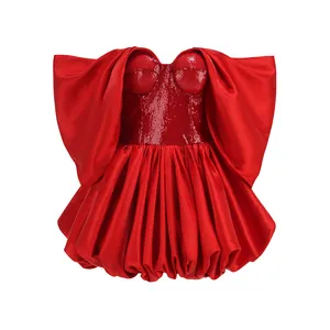 Vista frontale di un mini abito rosso con paillettes, orlo a sbuffo voluminoso e senza spalline