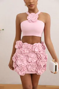 Detailed view of pink two-piece set featuring 3D floral halter top and matching mini skirt
