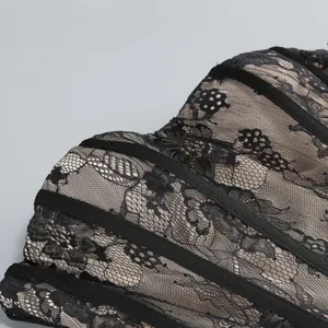 Dettaglio macro del pizzo nero e della struttura a stecche su un abito da sera sexy a tubino