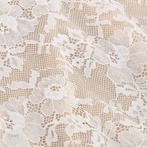 Macro detail view of white floral lace fabric with intricate jacquard pattern for women dress
