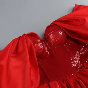 Dettaglio di un corpino rosso con paillettes e fiocco di raso per abito da sera