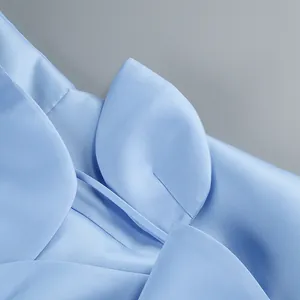 Gros plan sur une robe en satin bleu clair avec des pétales de fleurs décoratifs en 3D