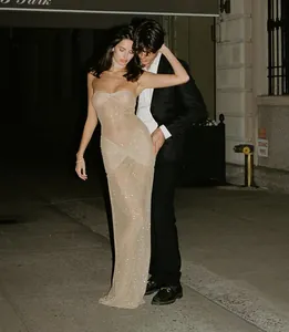 Elegant sheer strapless shimmering evening gown with delicate ruched detailing on street