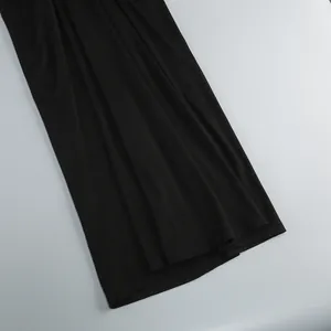 Primo piano del tessuto nero liscio e dell'elegante drappeggio dell'orlo dell'abito lungo
