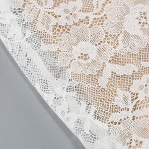 Close-up macro detail of delicate white floral lace fabric on a very stylish dress