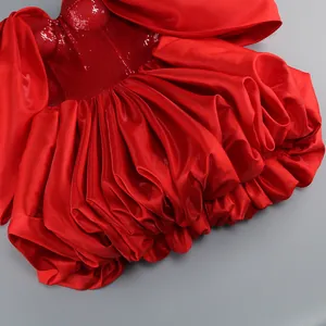 Primo piano del corpetto di paillettes rosse e della voluminosa gonna in raso a balze