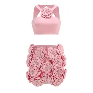 Detailed view of pink halter crop top and mini skirt with 3D fabric flower decor.