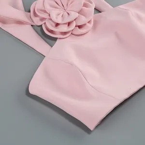Close-up of pink halter top featuring detailed 3D flower decoration and elegant texture