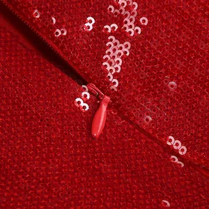 Primo piano dettagliato di un abito rosso con paillettes e cerniera invisibile sul retro