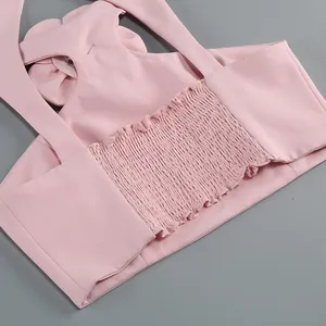 Close-up detail of pink halter neck top showing the elasticated smocked back and flower