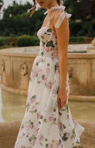 Romantic floral midi dress featuring elegant tie-shoulder straps and a bustier neckline detail.