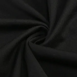 Dettaglio macro del tessuto nero che mostra la trama a maglia e il drappeggio pregiato.