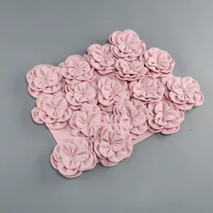 Close-up detail of a pink top or skirt adorned with many elegant 3D fabric flowers
