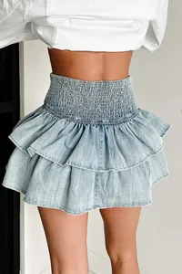 Detailweergave van lichtblauwe denim rok met ruches en gesmokte hoge taille