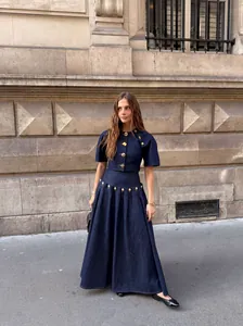 Κομψό σετ από σκούρο μπλε denim crop top και μακριά φούστα με χρυσά μεταλλικά κουμπιά.