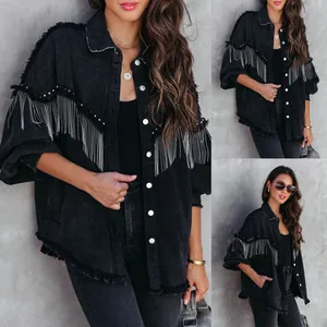 Detailed view of black denim jacket with silver chain fringes and rivet accents