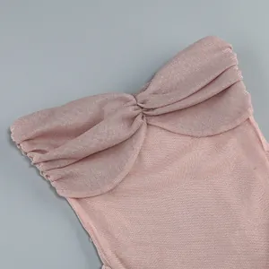 Detail of pink pleated sheer tube dress showing fine fabric texture and ruching.