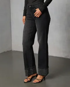 Detailed view of black washed straight denim jeans featuring sparkling rhinestone hem detailing.