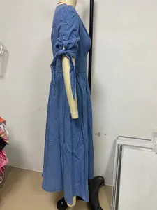 Side view of a blue denim V-neck maxi dress with tie-up puff sleeves on a mannequin