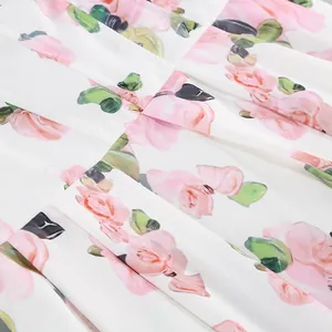Detail shot of elegant pink rose floral print and pleats on white dress fabric