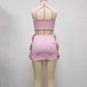 Detailed back view of pink two-piece set featuring halter crop top and floral skirt