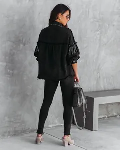 Back view of black denim jacket with heavy rivet and chain detailing for street style.