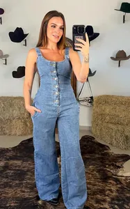Stylish blue denim jumpsuit with front buttons and wide-leg pants in a Western-style setting