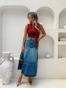 Detailweergave van de high-waisted A-lijn denim maxi-rok met een gelaagd splitontwerp.