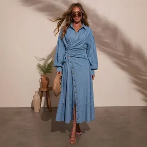 Detail of light blue denim maxi dress with lantern sleeves and wrap-style waist