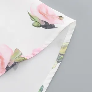 Detailed view of the stitched hem on a white floral print midi dress for women