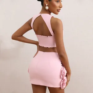 Elegant pink two-piece summer set featuring a cutout crop top and floral mini skirt