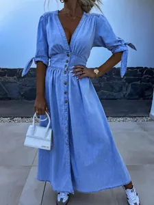 Elegant V-neck light blue denim maxi dress with button front and tie-sleeve details.