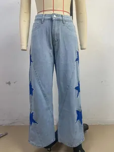 Detail of light wash straight leg jeans featuring blue star patches with pearl trim