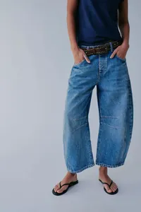 Close-up detail of women's barrel leg jeans with a relaxed mid-waist fit and vintage wash