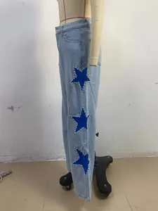 Detailed side view of women's light blue jeans with blue star patches and pearls