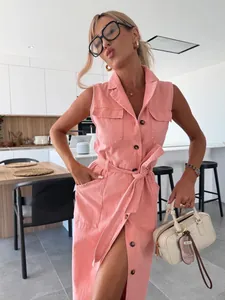 Robe longue en jean rose sans manches avec ceinture et boutons portée par un mannequin