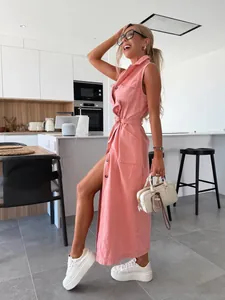 Femme en robe longue en jean rose sans manches avec ceinture dans une cuisine moderne