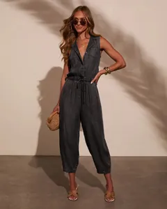 Full-length view of a chic dark wash sleeveless denim jumpsuit on a fashion model.