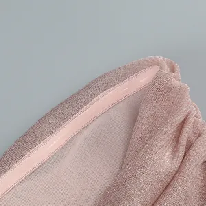 Close-up of elegant pink shimmery pleated fabric detailing on a slim-fit evening dress.